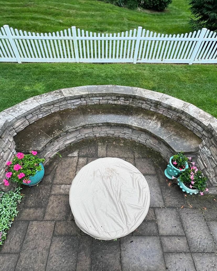 A paver patio and curved stone seat wall, before washing