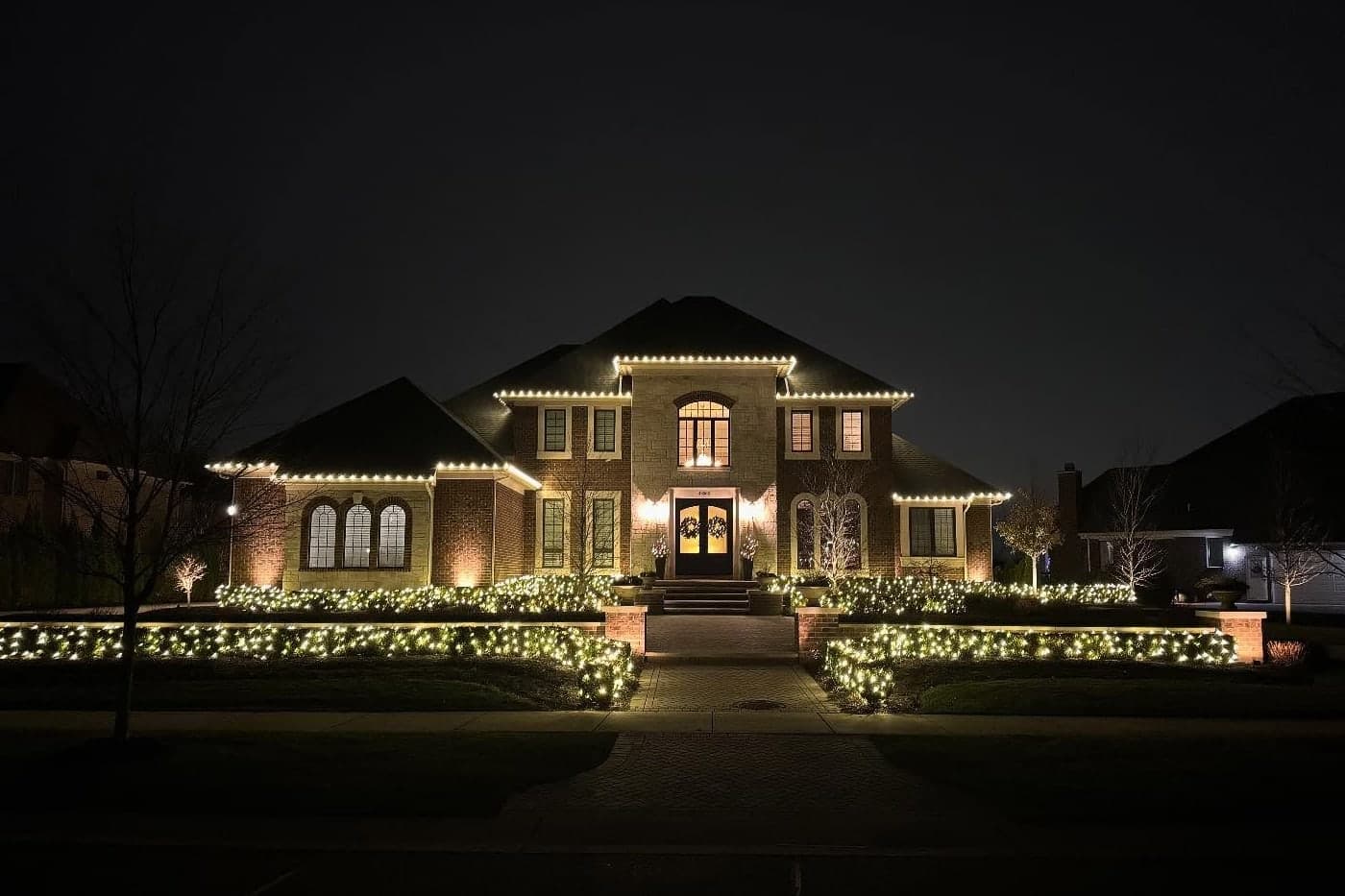 A large brick home at night with warm white C9 bulbs running the full length of every gable and eave