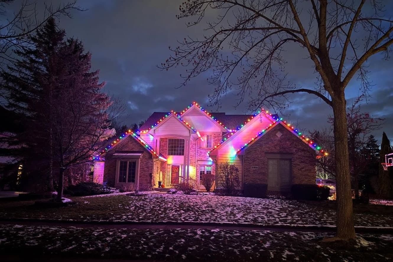 Multicolor Christmas lights on a roofline at dusk