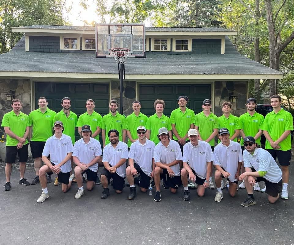 The Glass Guru team in green and white branded polos, lined up in front of a garage
